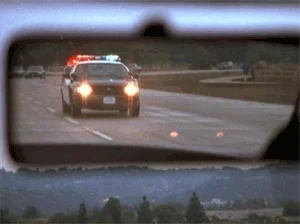 Police cars seen from rearview mirror
